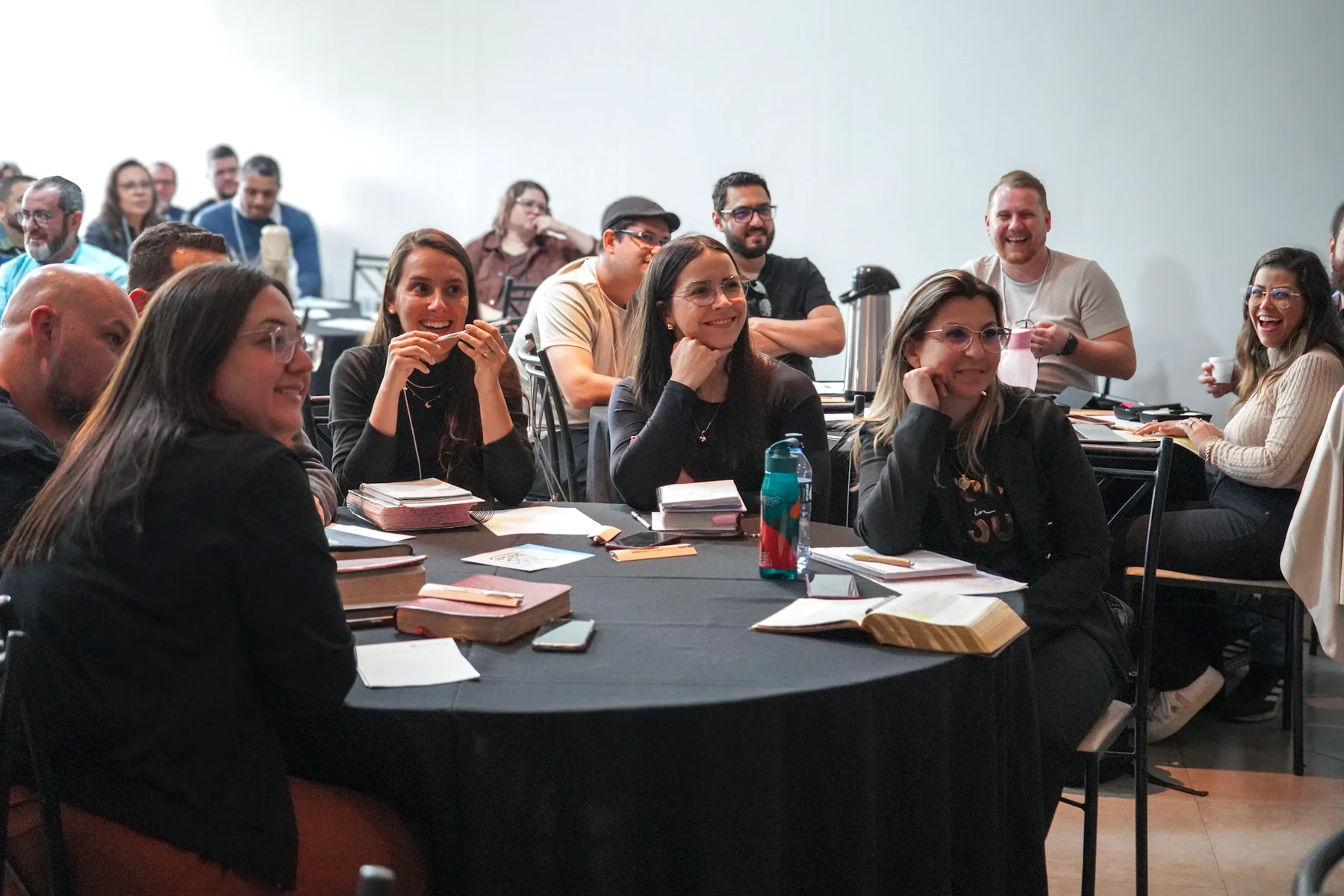 Pessoas reunidas em uma mesa durante um encontro da Converge Brasil.
